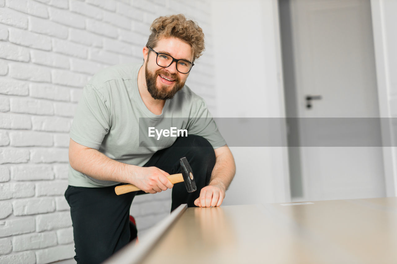 young man using mobile phone while standing at home