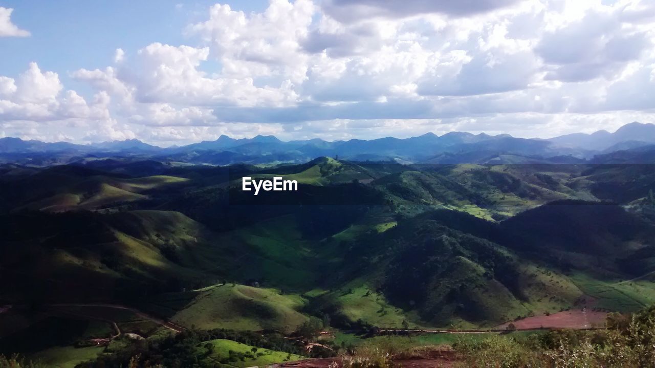 Scenic view of field and mountains against sky