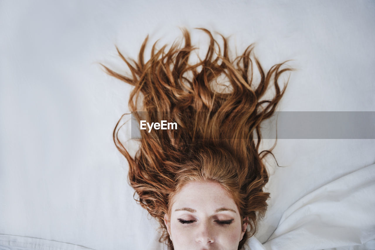 Redhead woman sleeping on bed