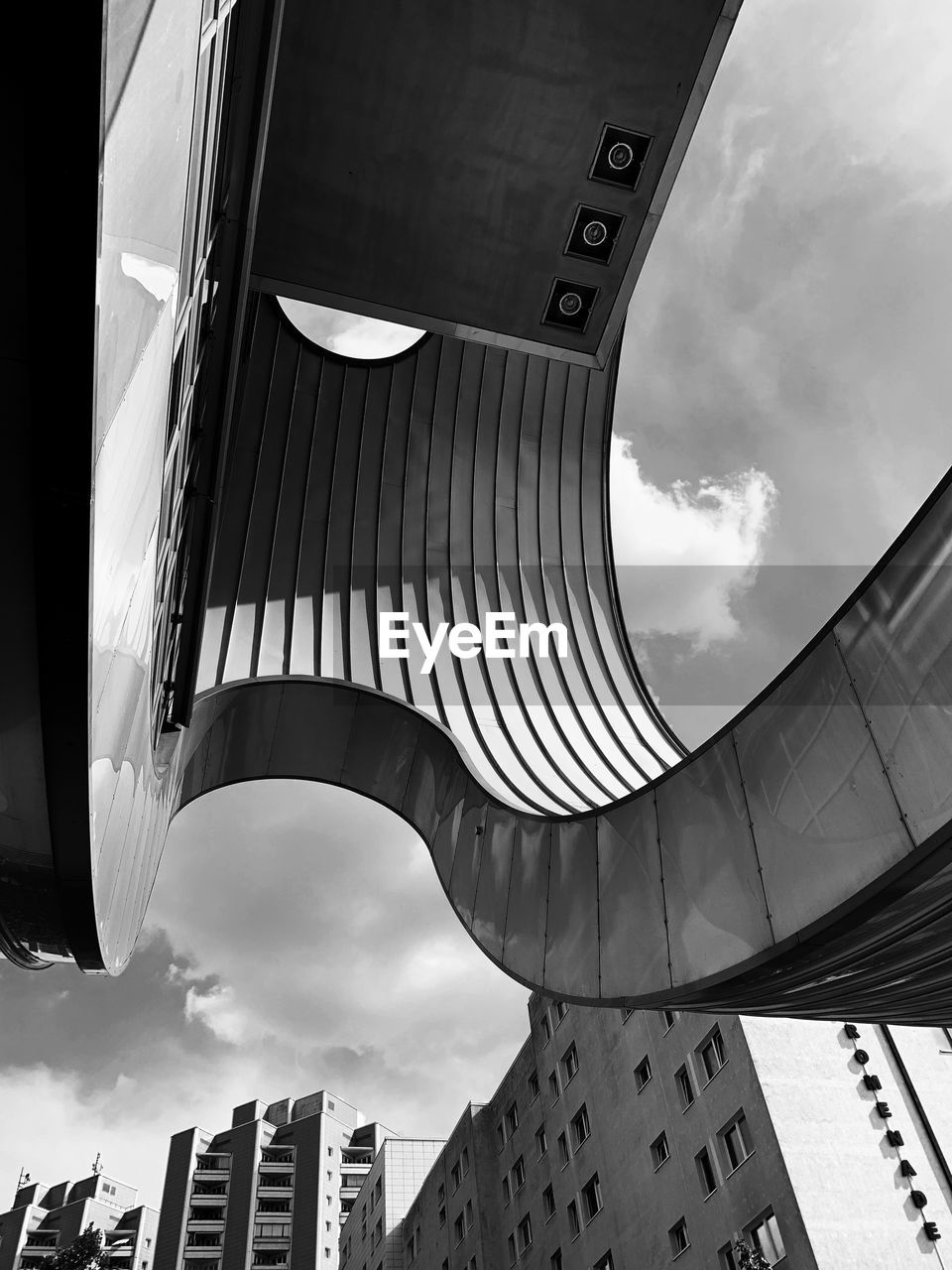 Low angle view of modern building against cloudy sky