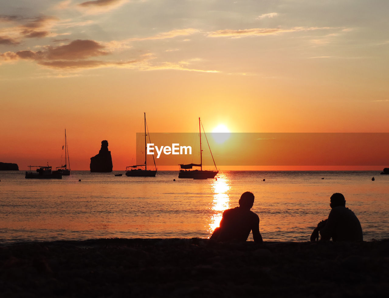 SILHOUETTE PEOPLE ON BEACH AT SUNSET