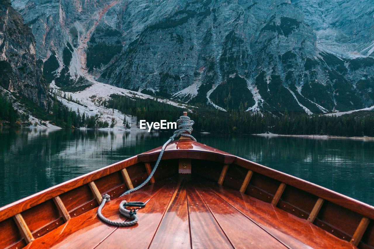 Boat on lake against mountain during winter