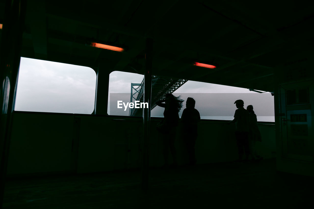 Low angle view of silhouette people at observation point by onaruto bridge