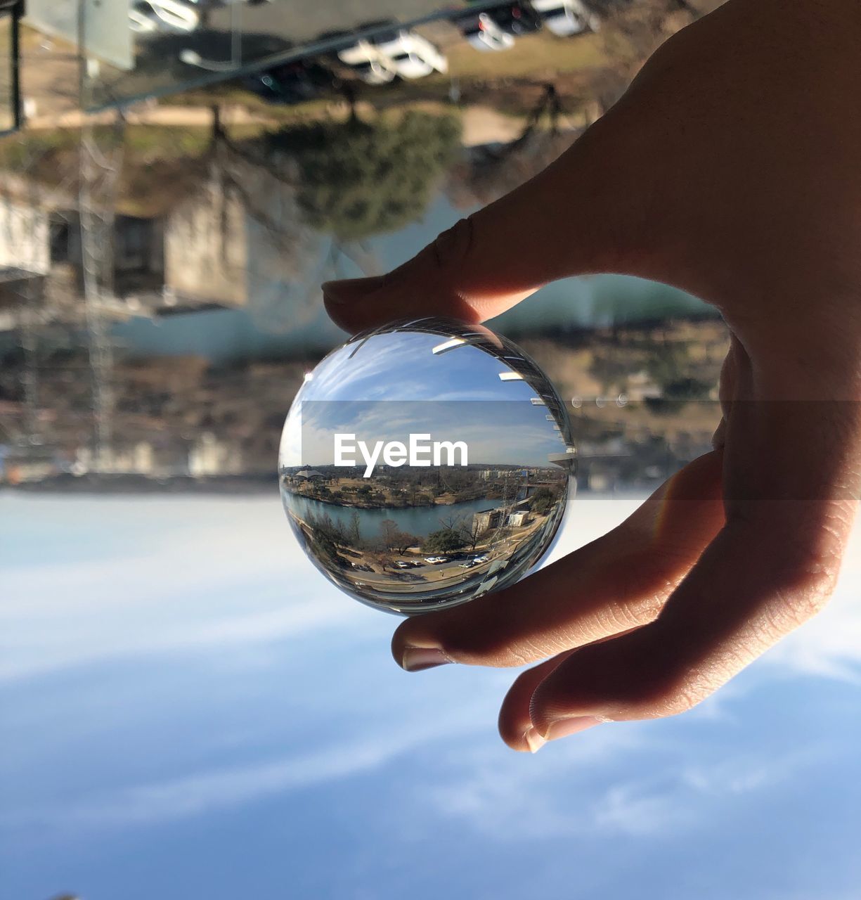 CLOSE-UP OF HUMAN HAND HOLDING CRYSTAL BALL