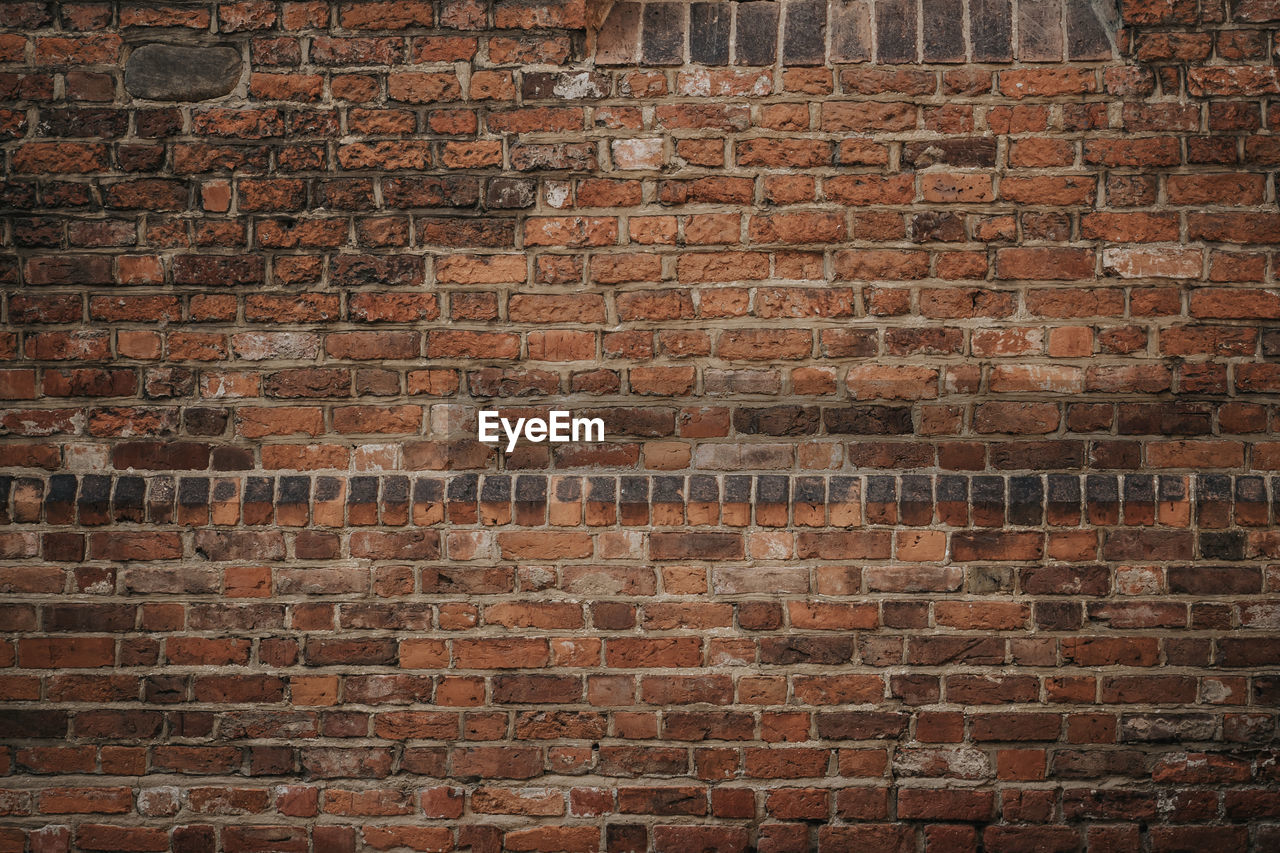 FULL FRAME SHOT OF BRICK WALL BY BUILDING