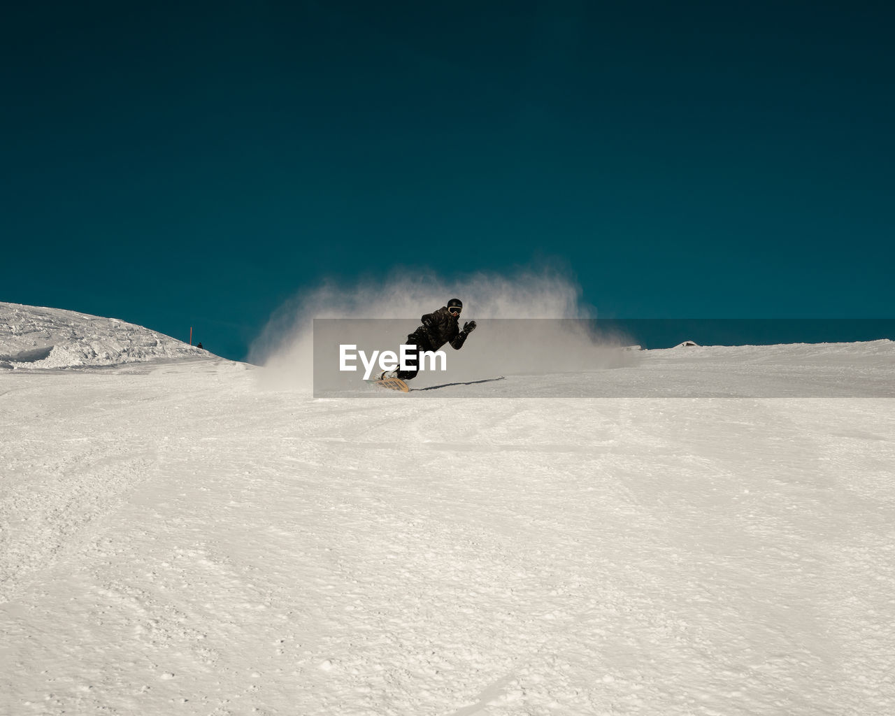 PERSON SKIING ON SNOWCAPPED MOUNTAINS AGAINST SKY