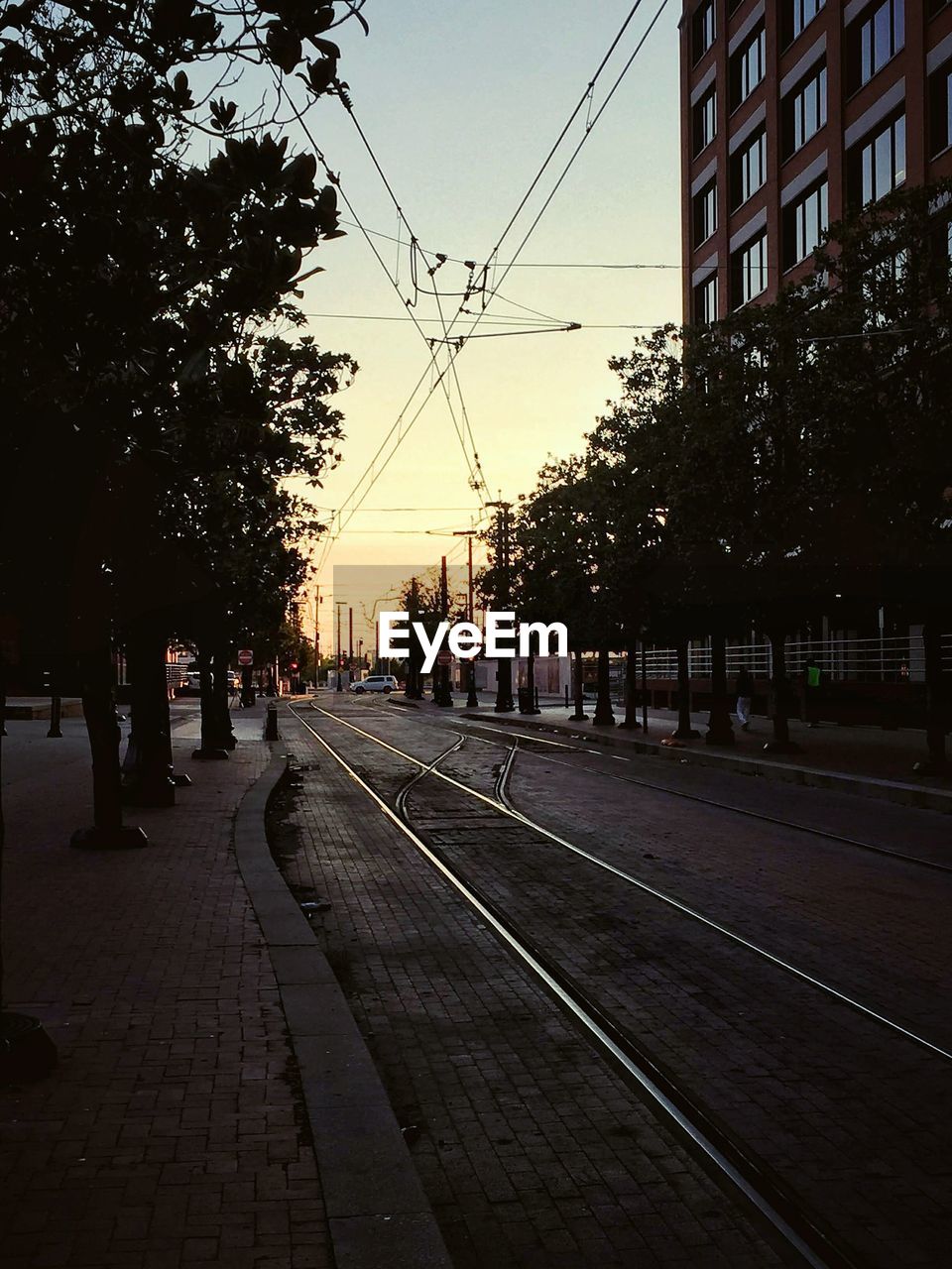 View of railroad tracks in city at sunset