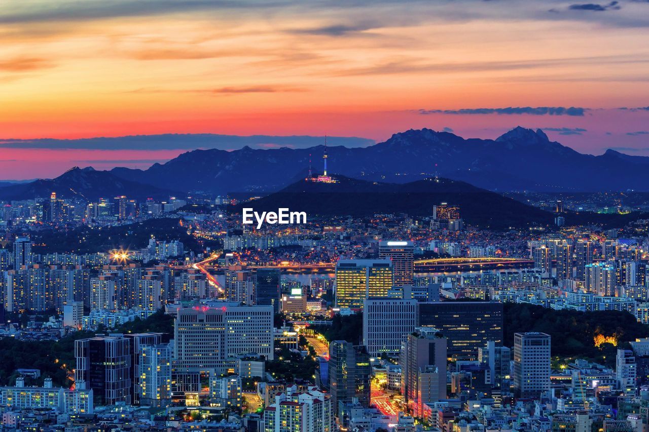 Aerial view of modern cityscape against sky during sunset