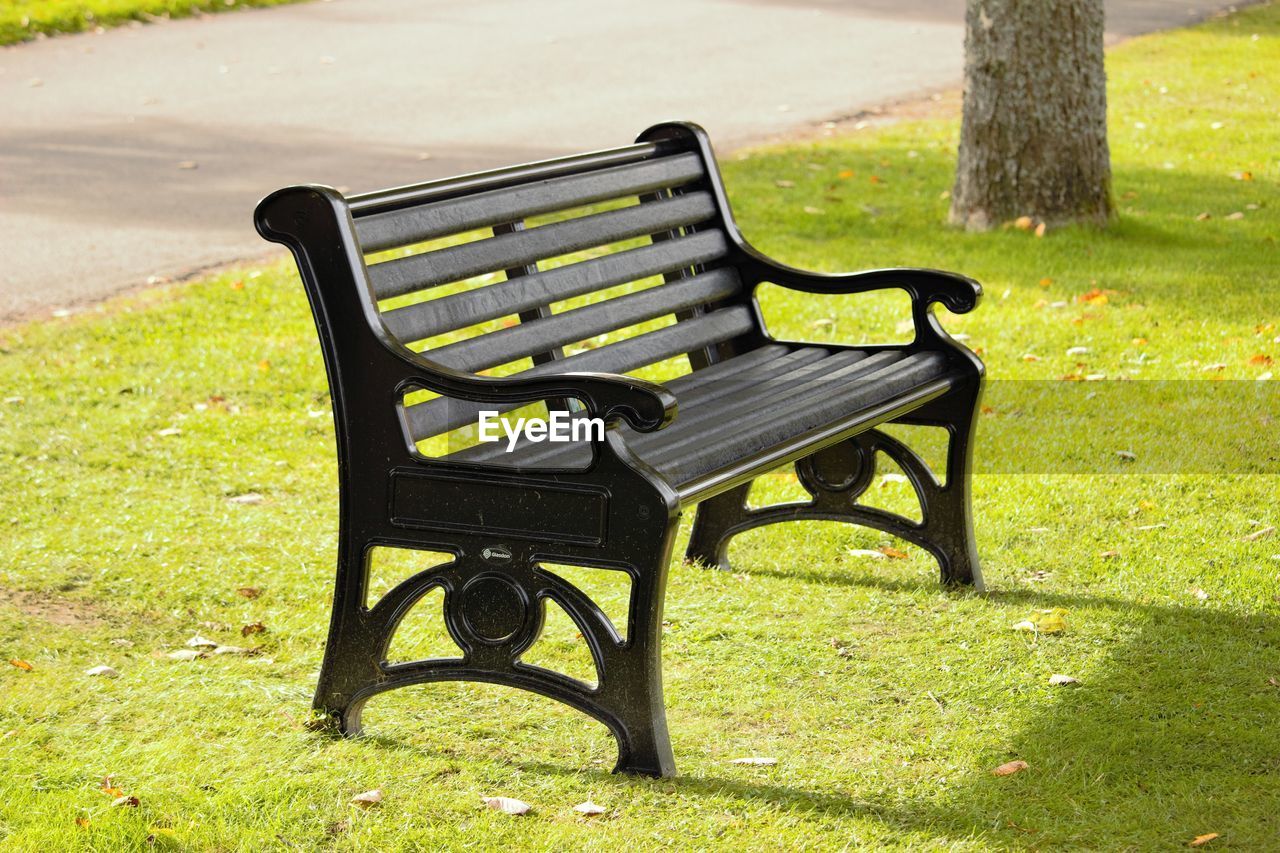 EMPTY BENCH IN PARK AGAINST SUNLIGHT