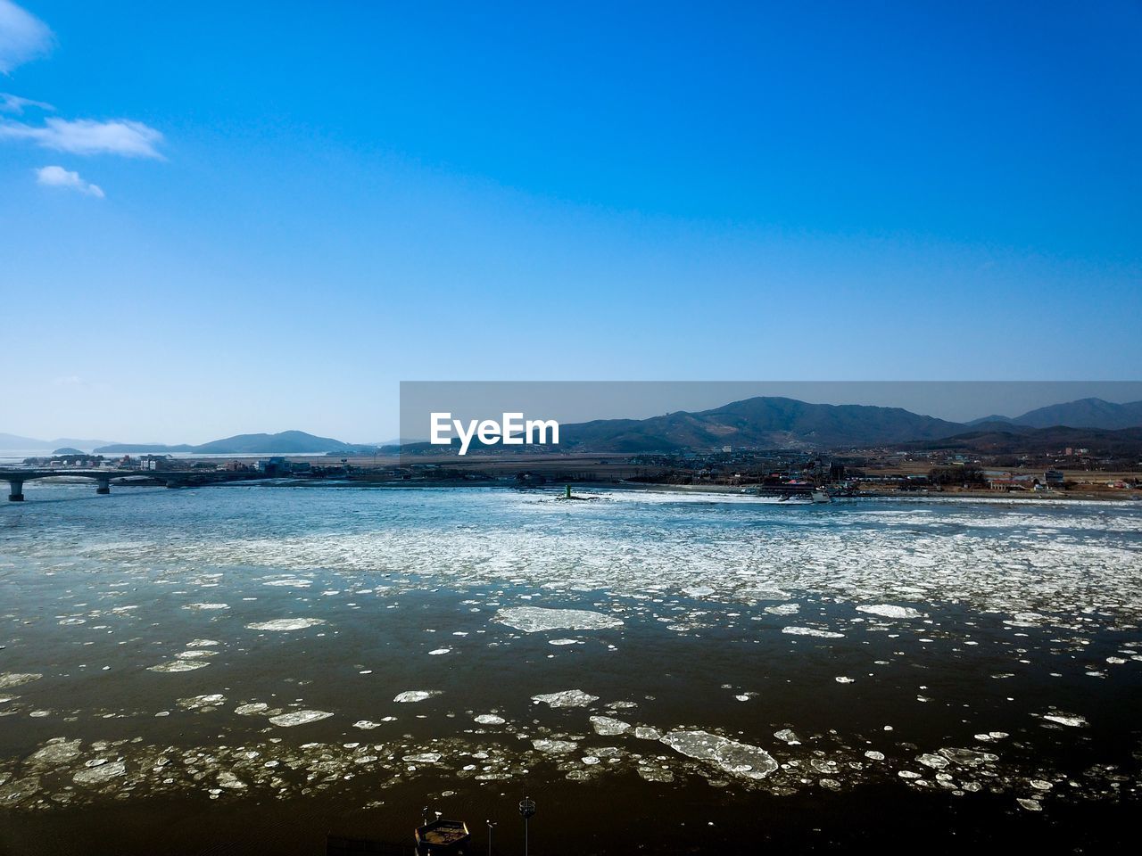 SCENIC VIEW OF SEA AND MOUNTAINS AGAINST BLUE SKY