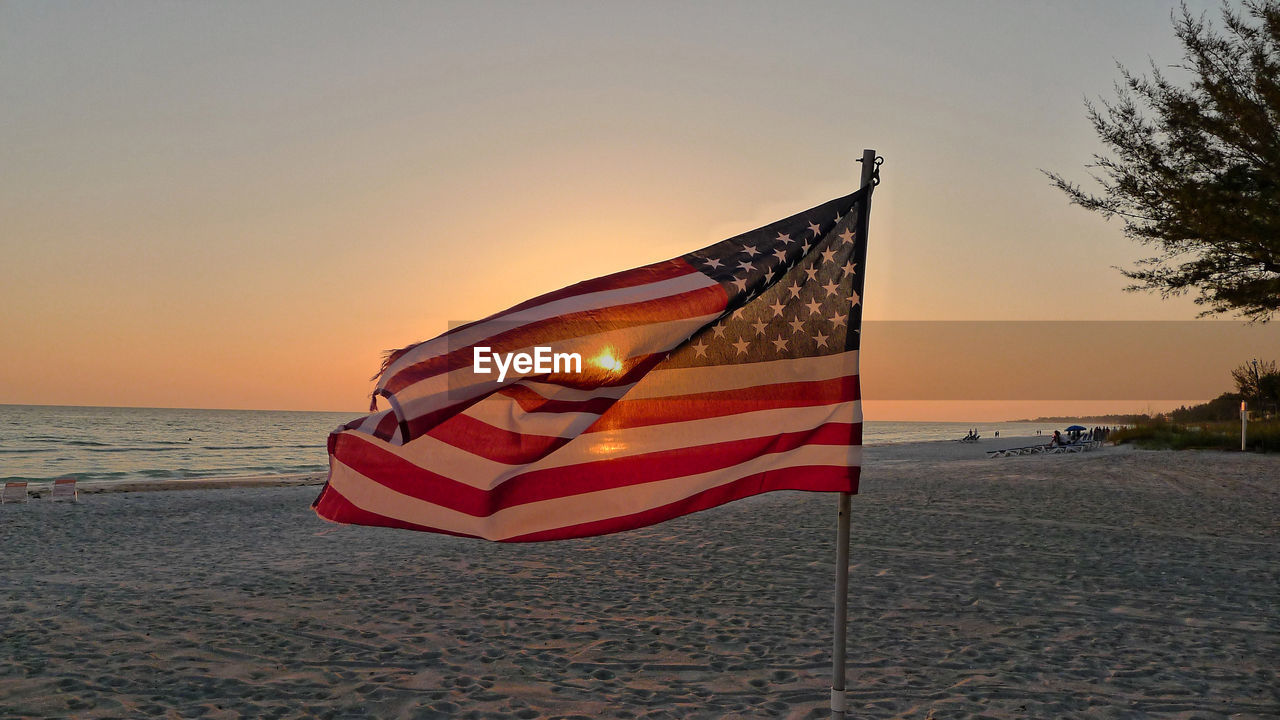 American flag flying against scenic sunset