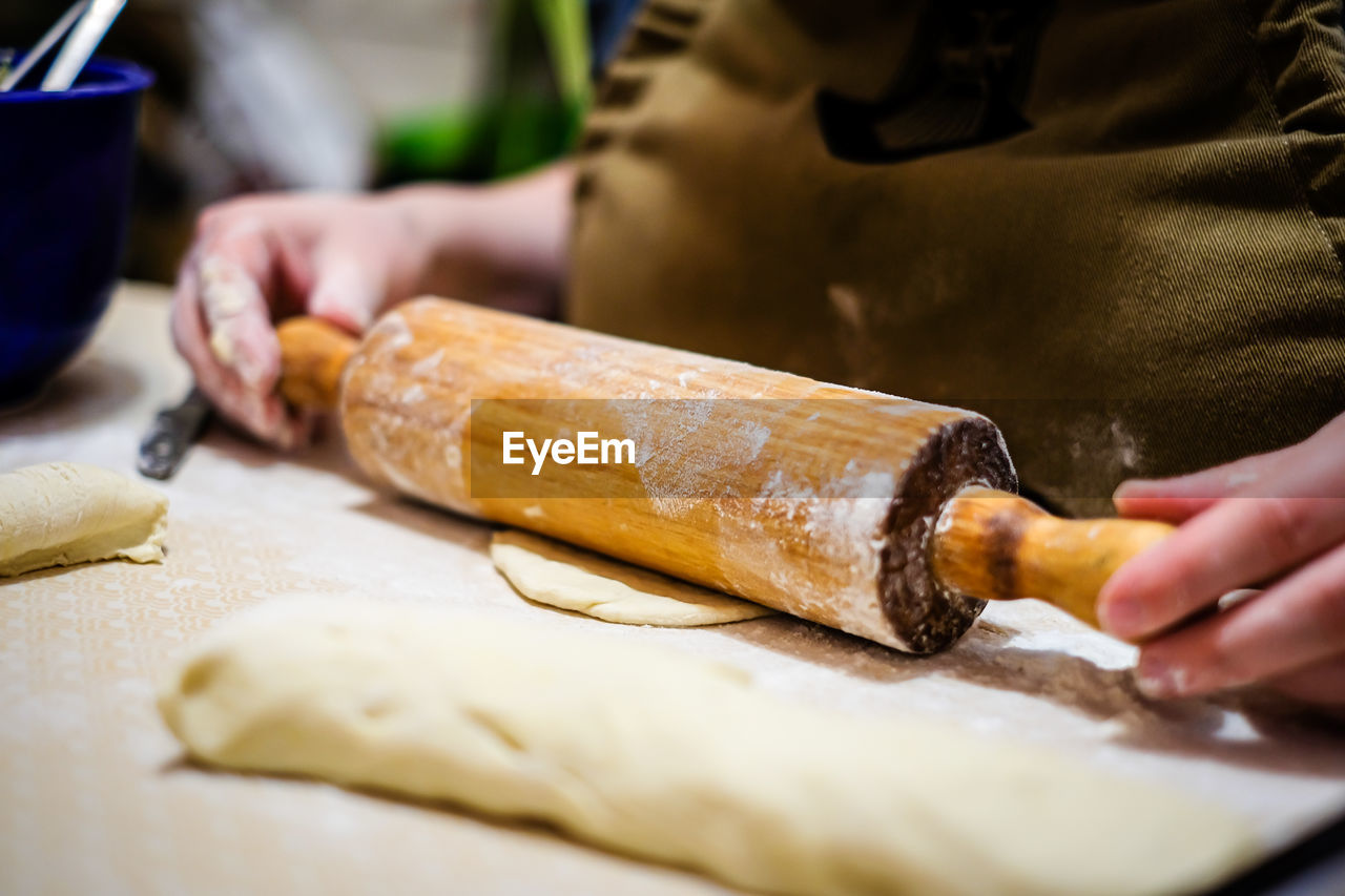 cropped hand of chef preparing food on table