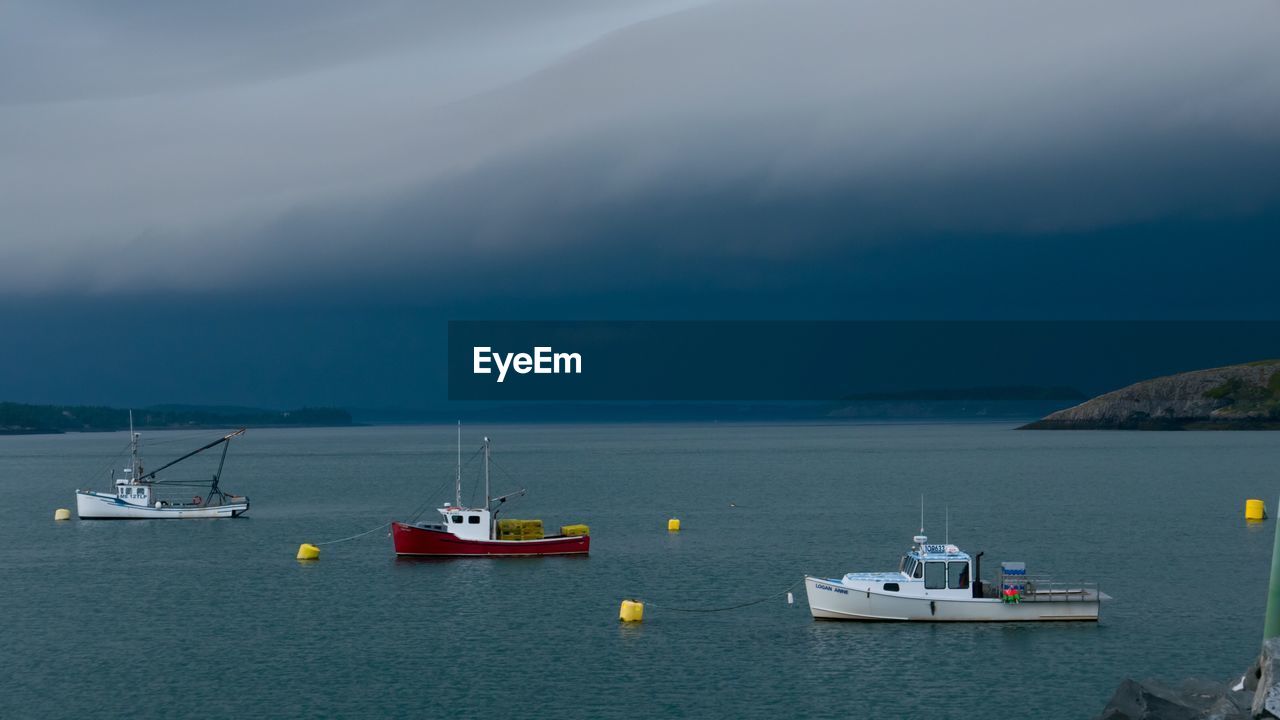 SAILBOATS IN SEA AGAINST SKY