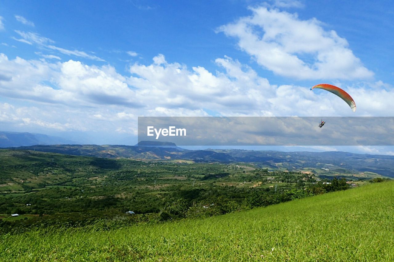 Paraglider above grassy field