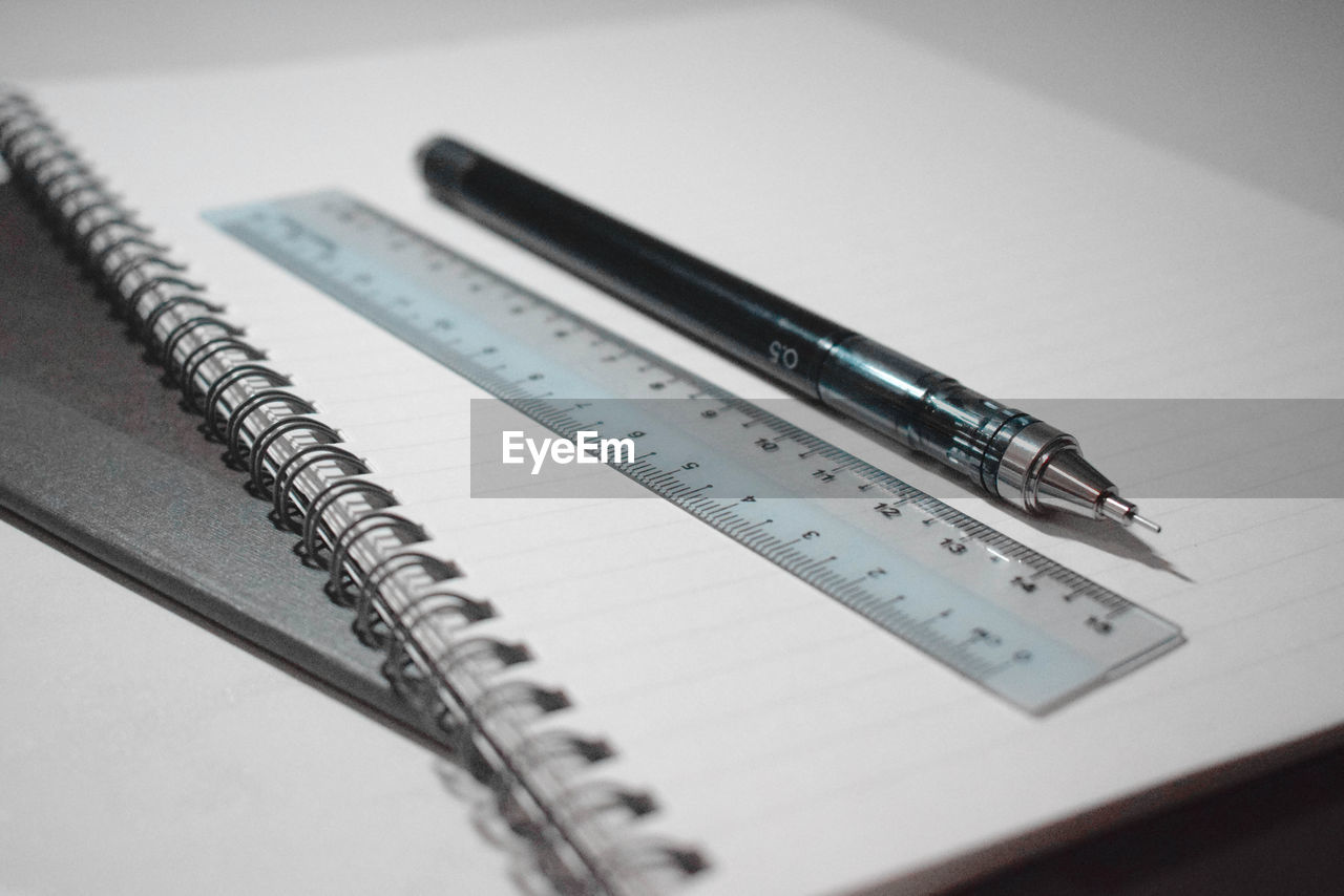 Close-up of pen and ruler on book