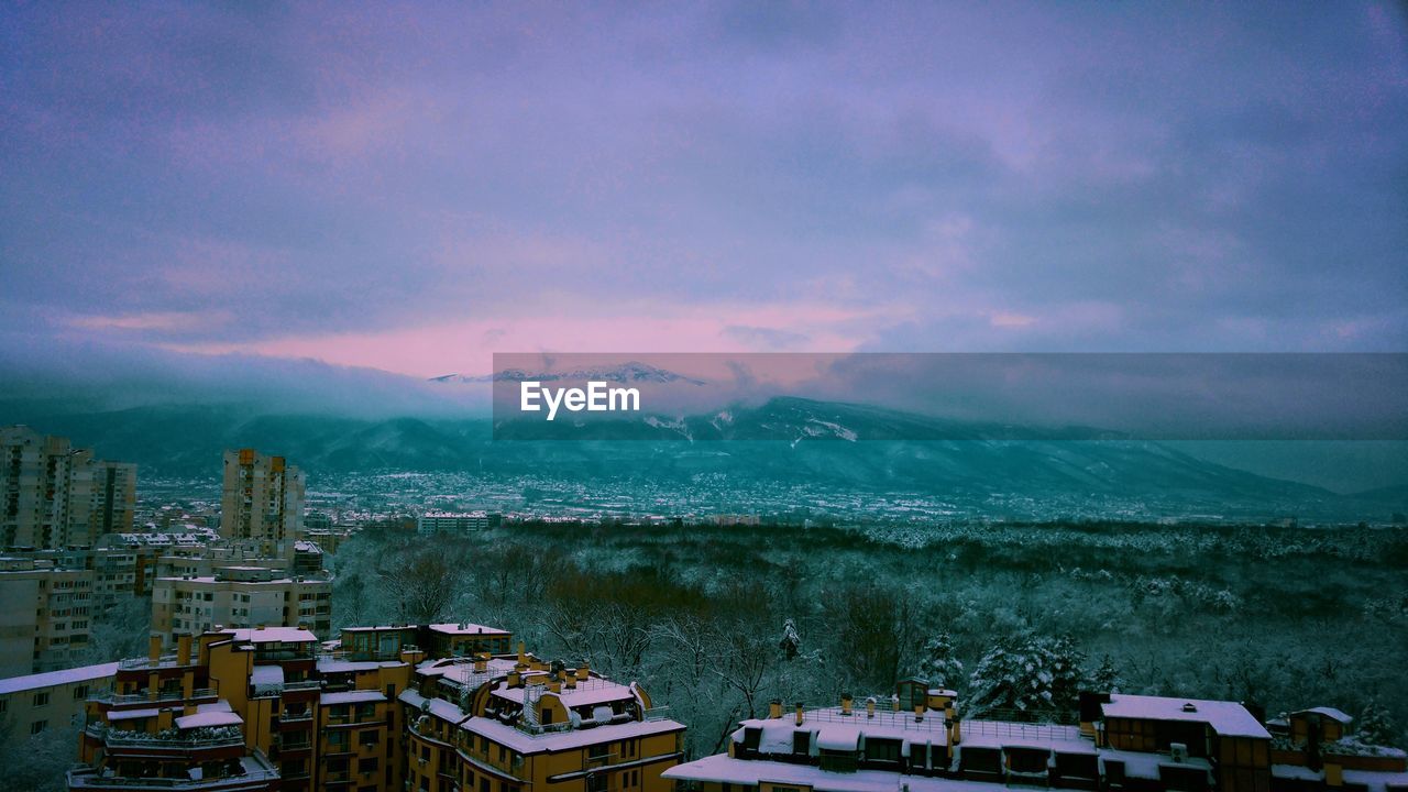 Aerial view of cityscape by sea against sky