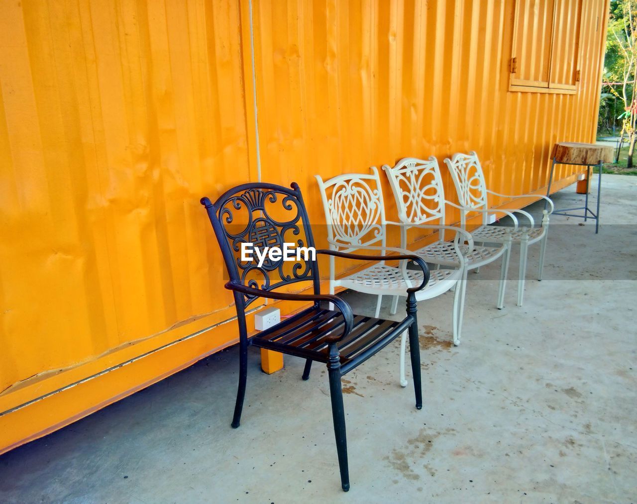 Empty chairs and table against yellow wall in building