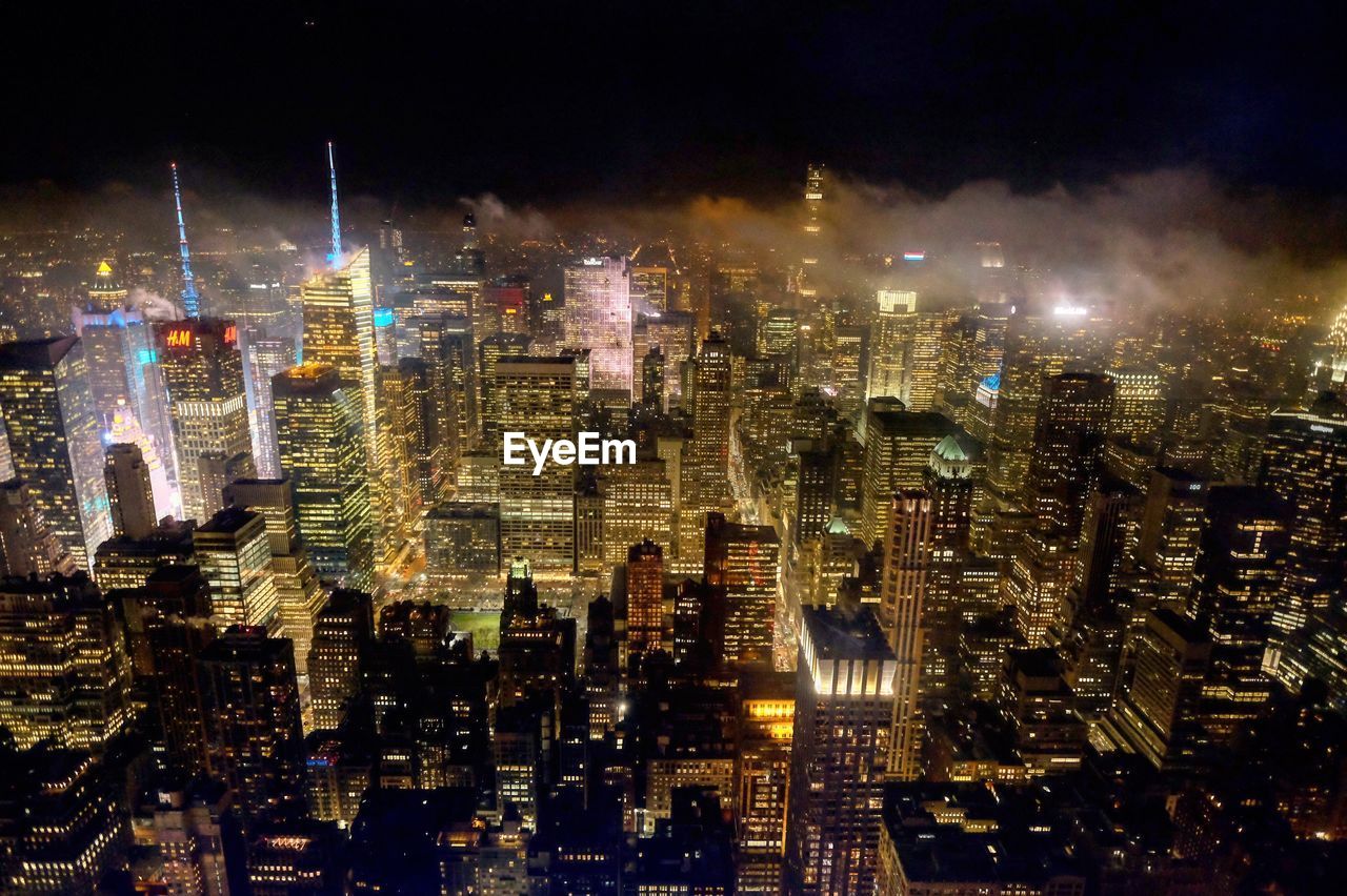 Illuminated cityscape against sky at night