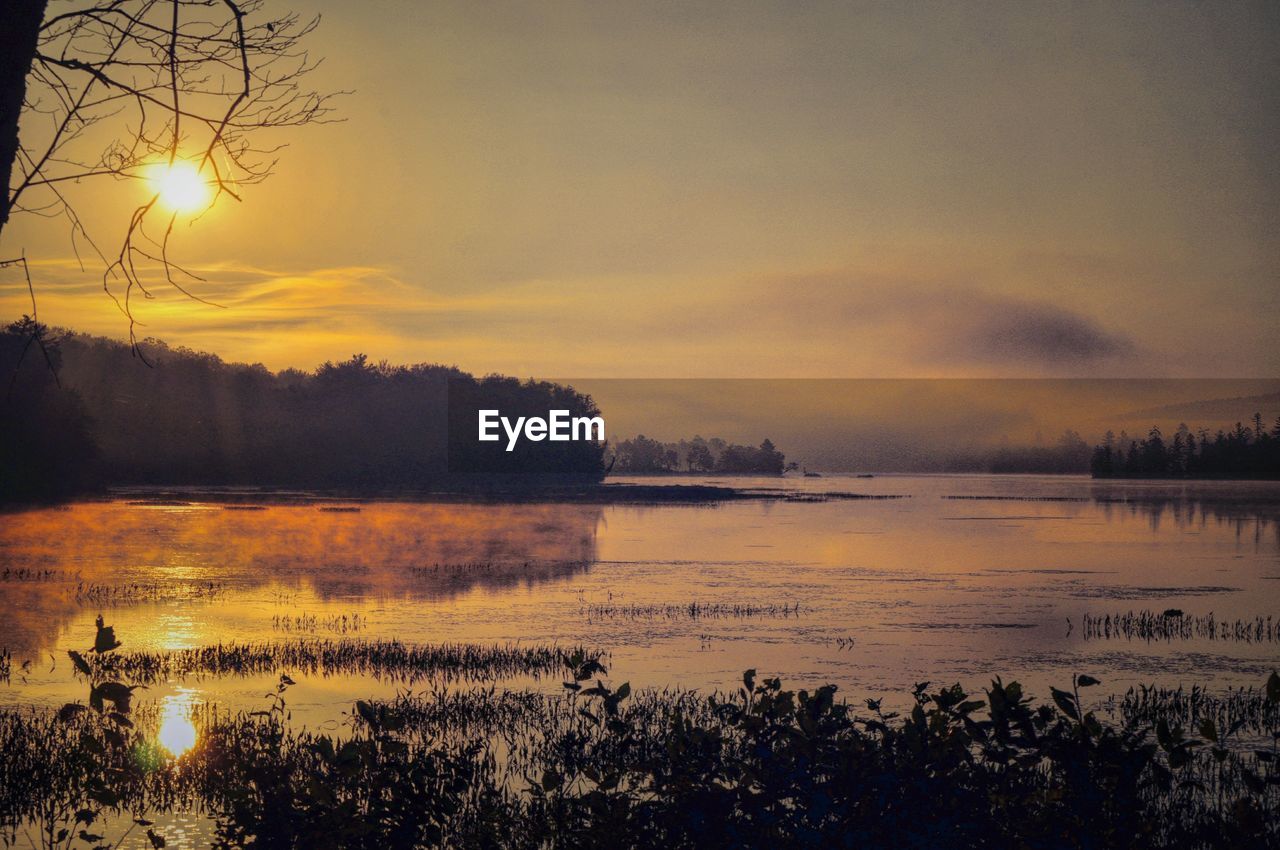 Scenic view of lake against orange sky