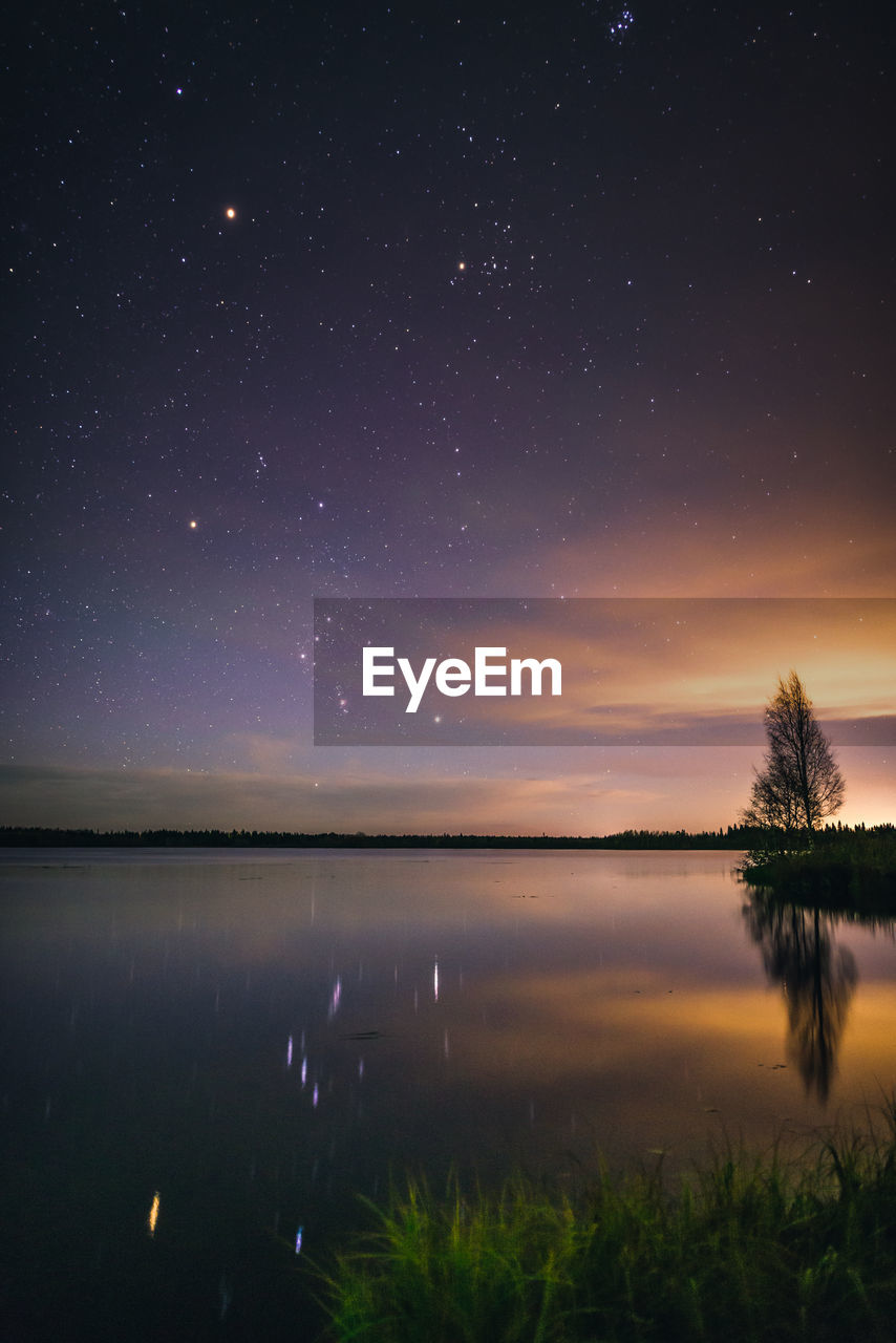 Scenic view of lake against sky at night