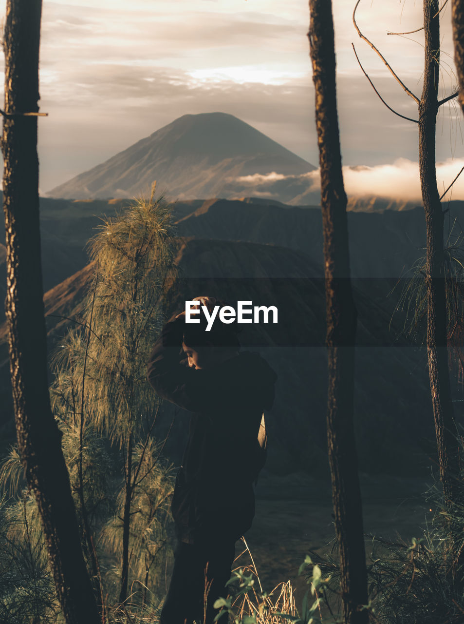 Man photographing on mountain against sky