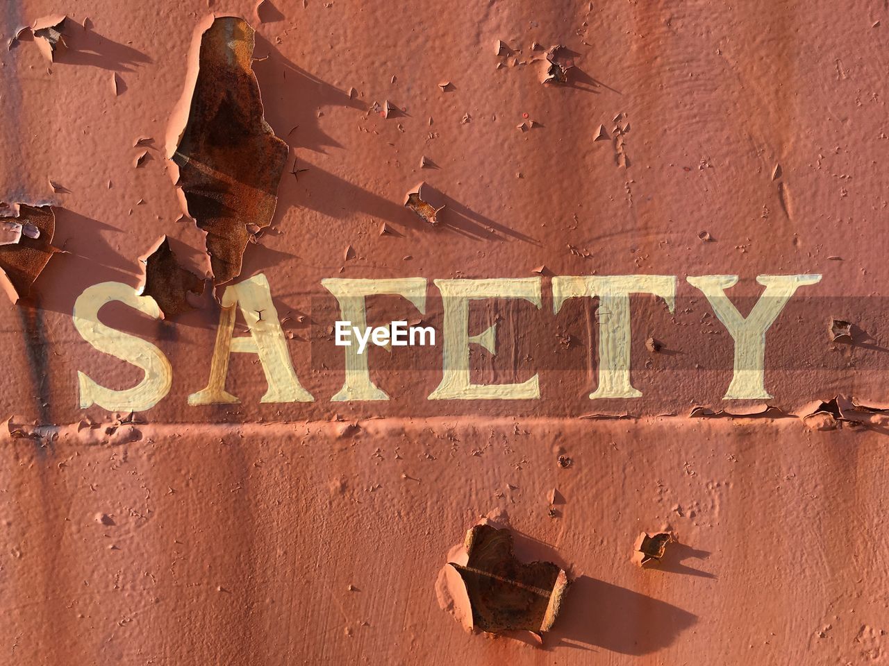 Close-up of safety text on rusty wall