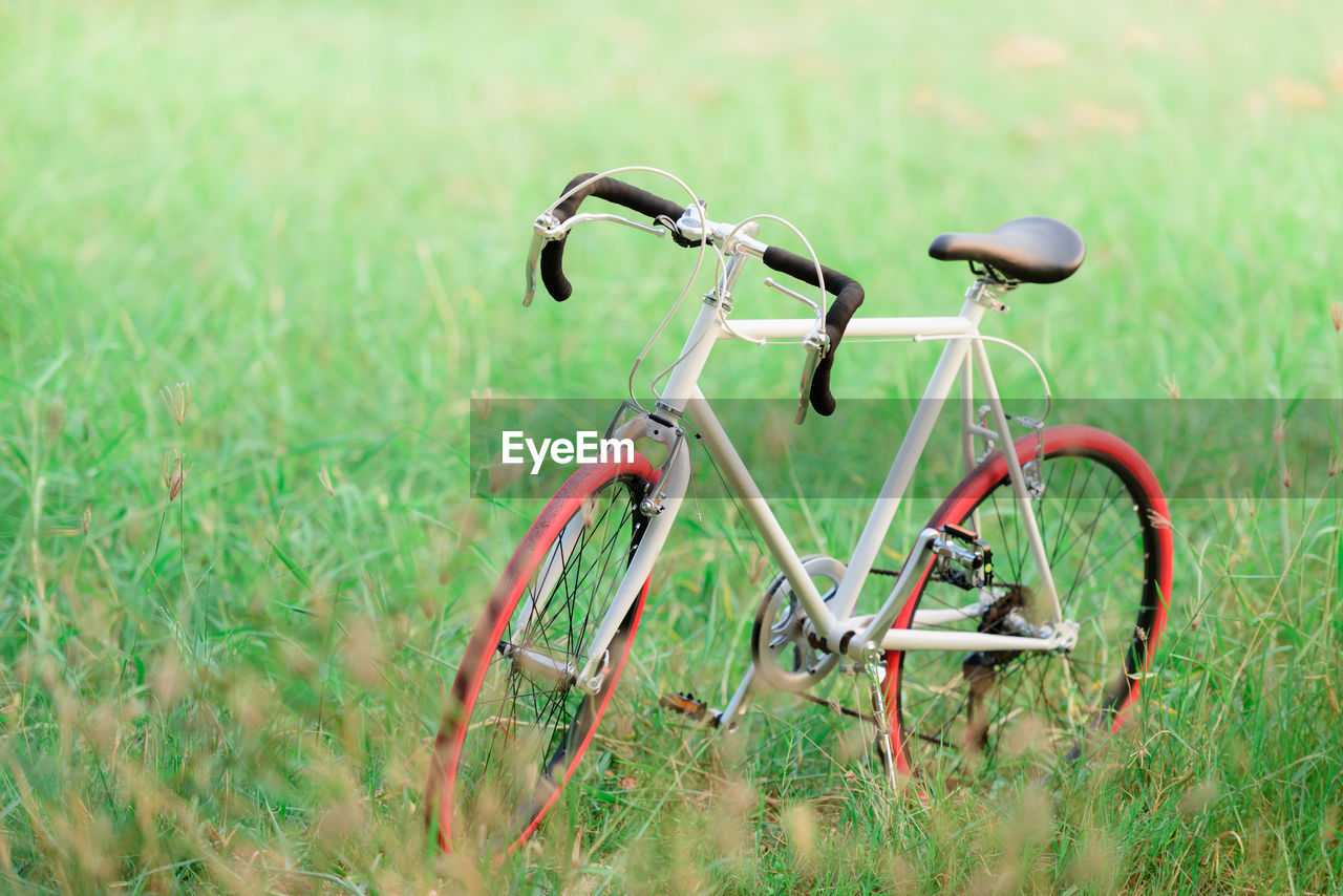 Bicycle on grassy field against sky