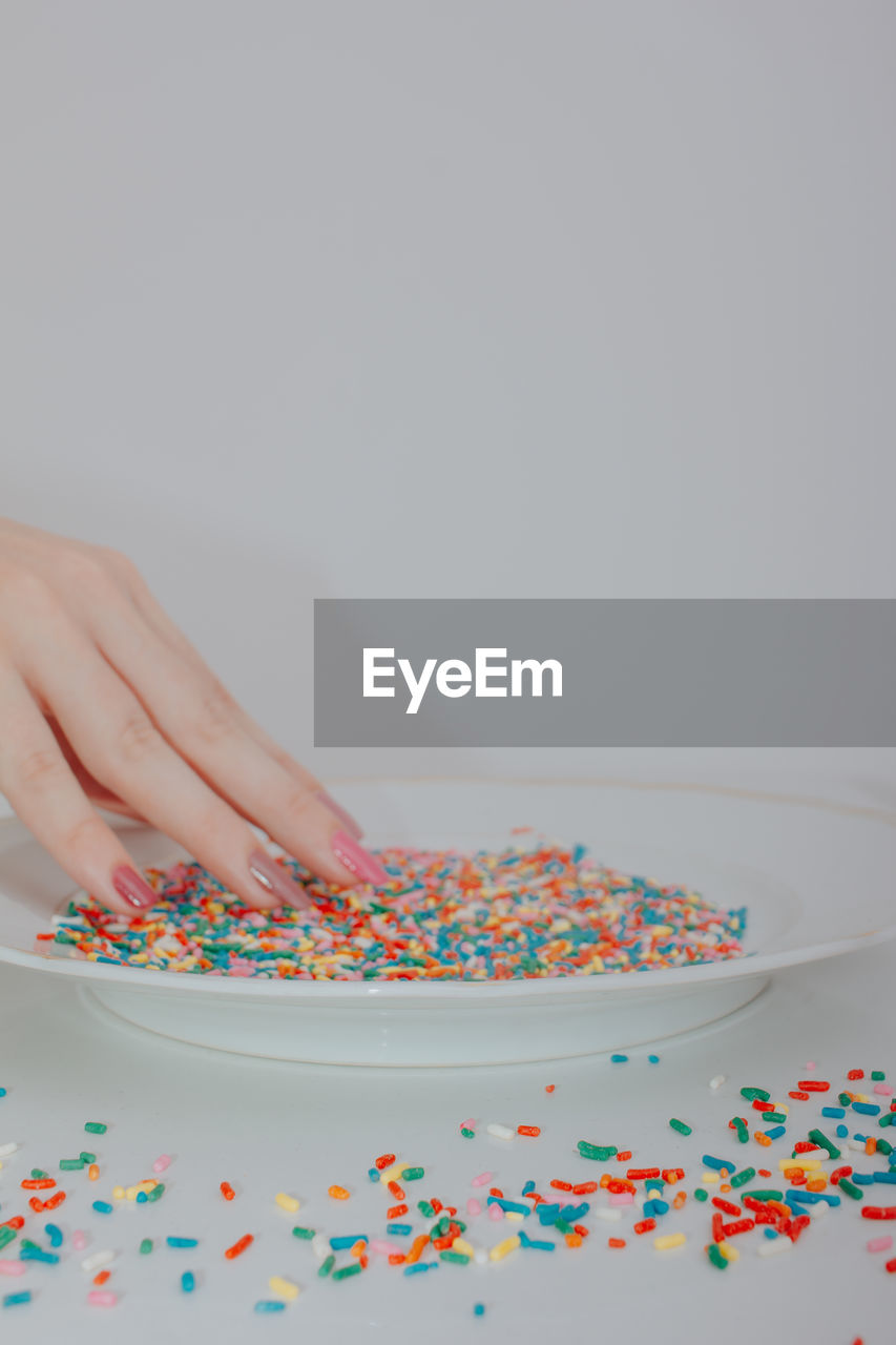 Hands holding plate full of colorful confetti