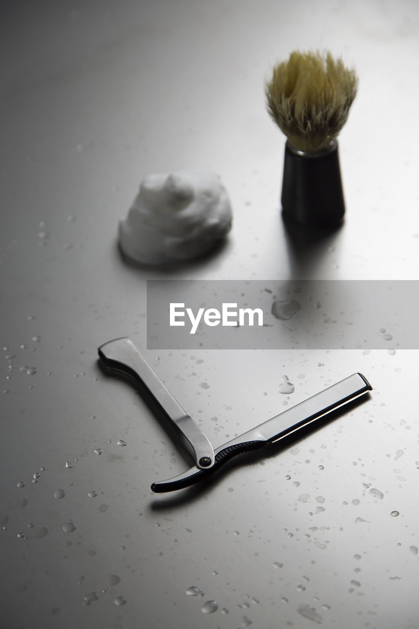 High angle view of shaving equipment on wet table