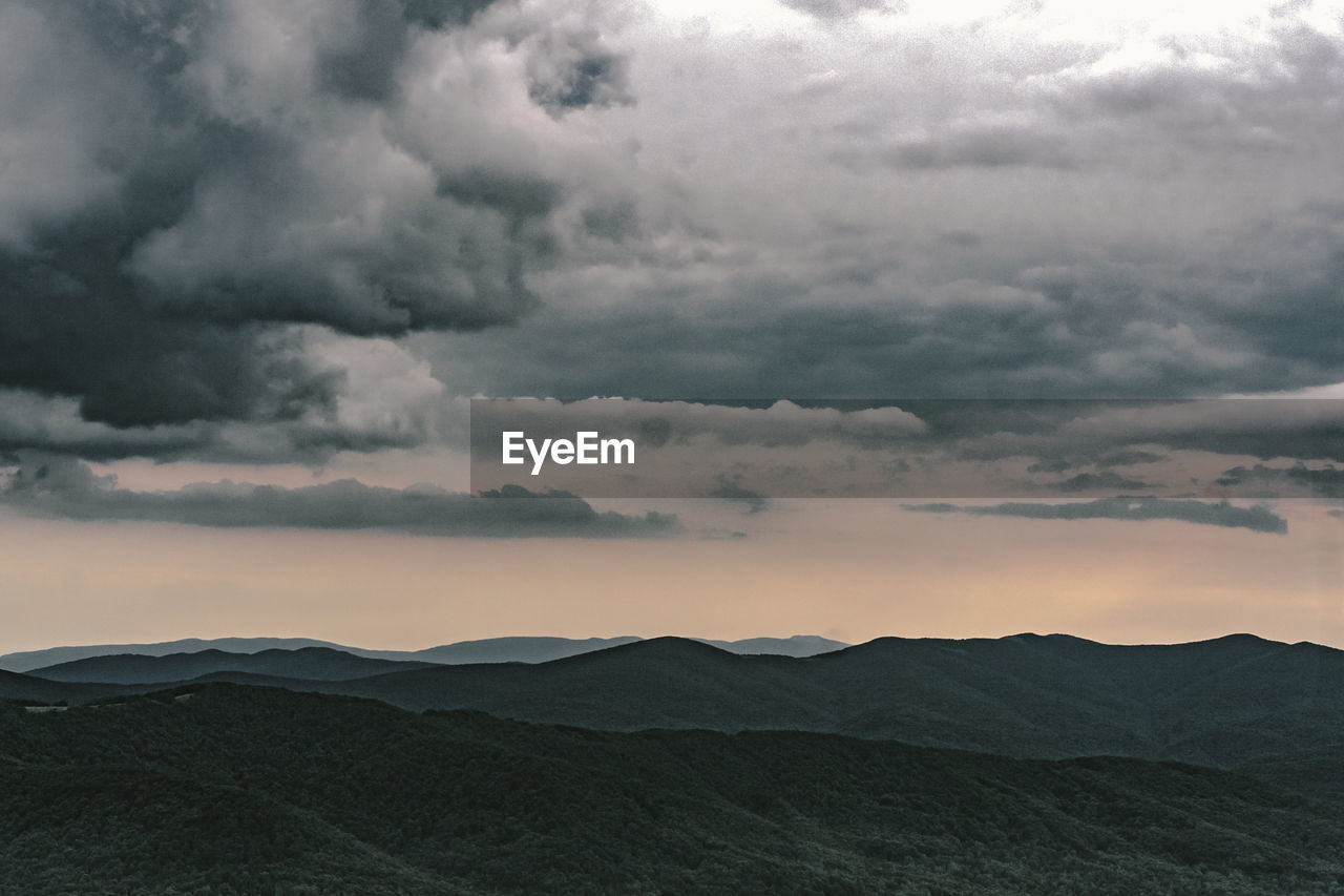 Scenic view of mountains against dramatic sky