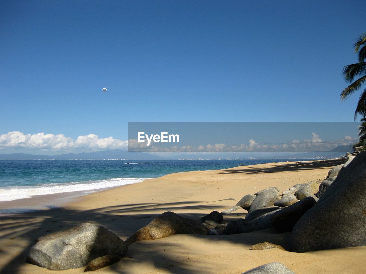 View of calm beach against blue sky