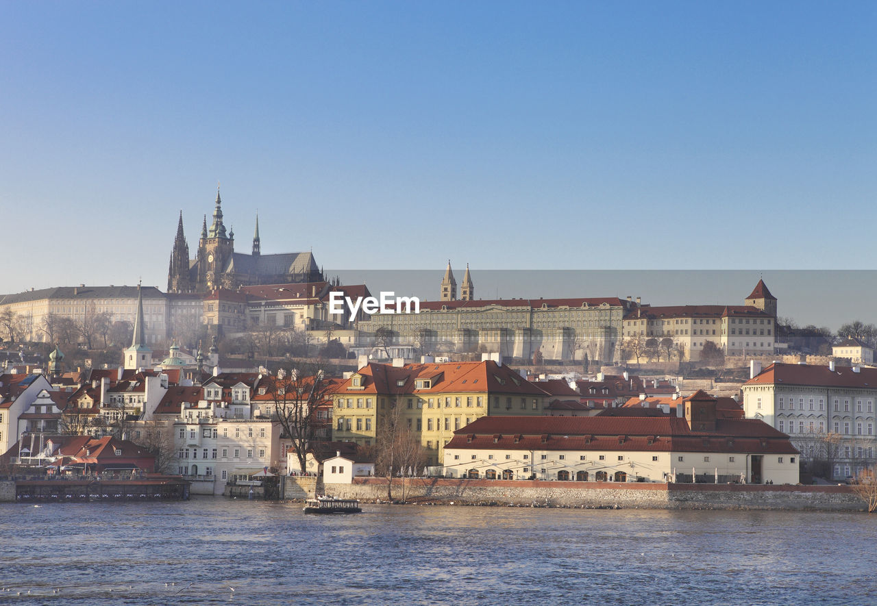 TOWN BY RIVER AGAINST BUILDINGS IN CITY