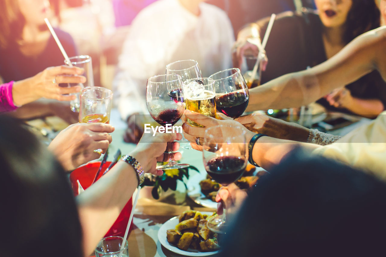 Close-up of people drinking glasses on table