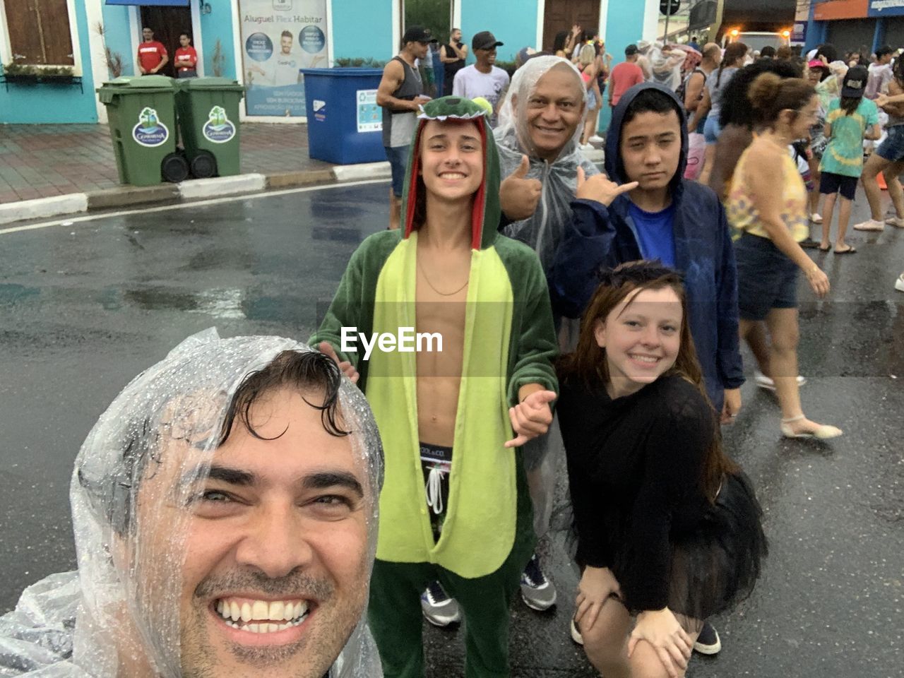 PORTRAIT OF A SMILING YOUNG WOMAN WITH PEOPLE IN THE BACKGROUND