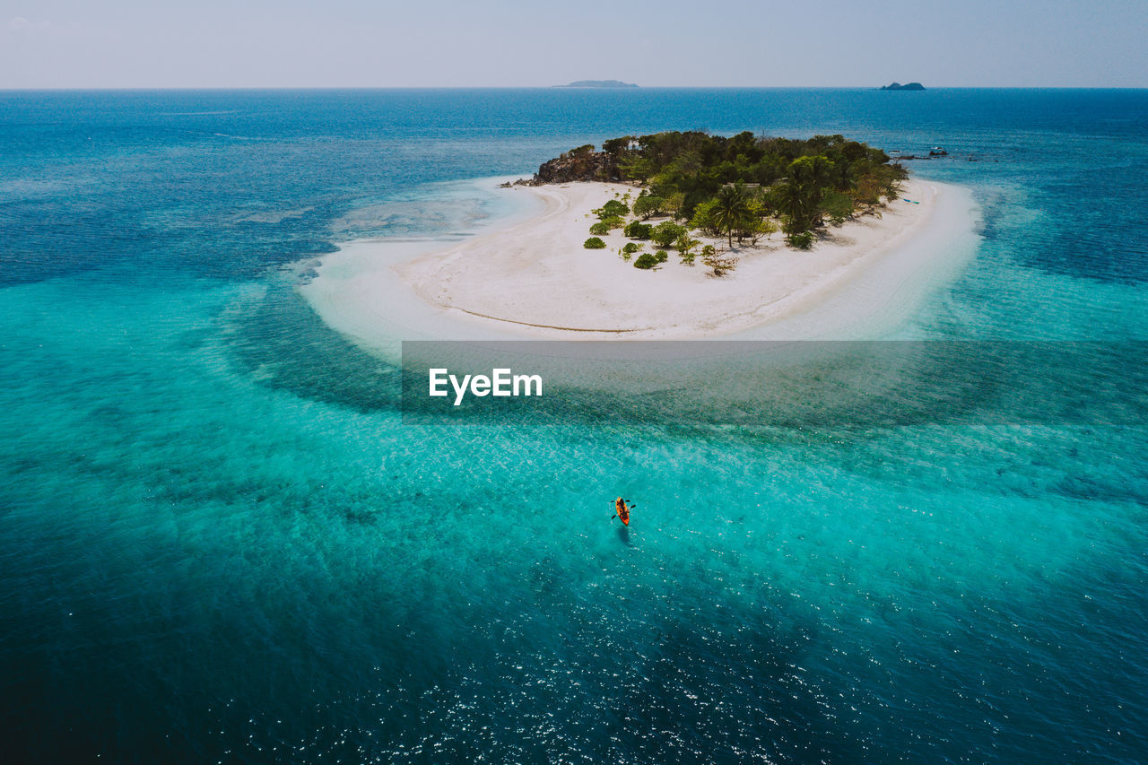 Drone view of couple kayaking in sea on sunny day