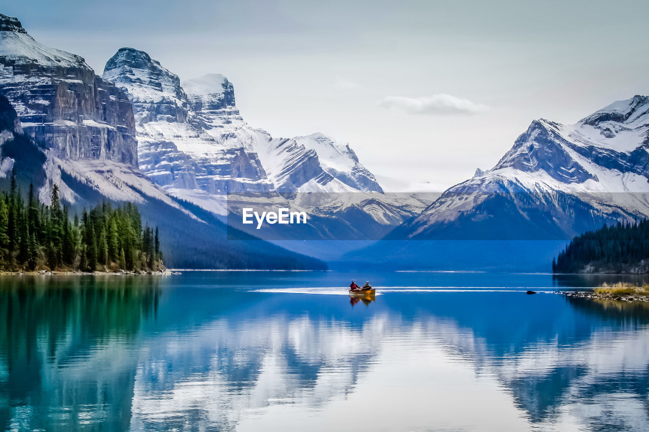 SCENIC VIEW OF LAKE BY SNOWCAPPED MOUNTAINS AGAINST SKY DURING WINTER