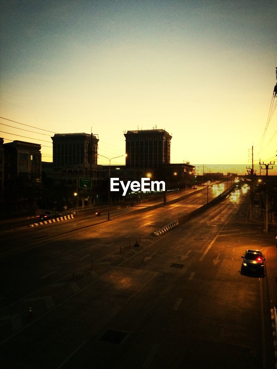 High angle view of street by buildings against clear sky during sunset