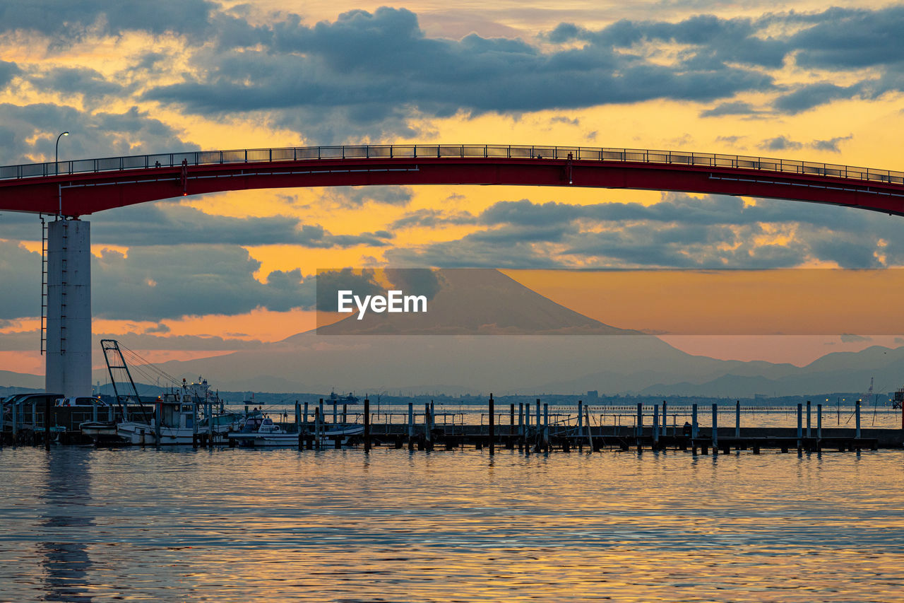 Pier over sea against sky during sunset