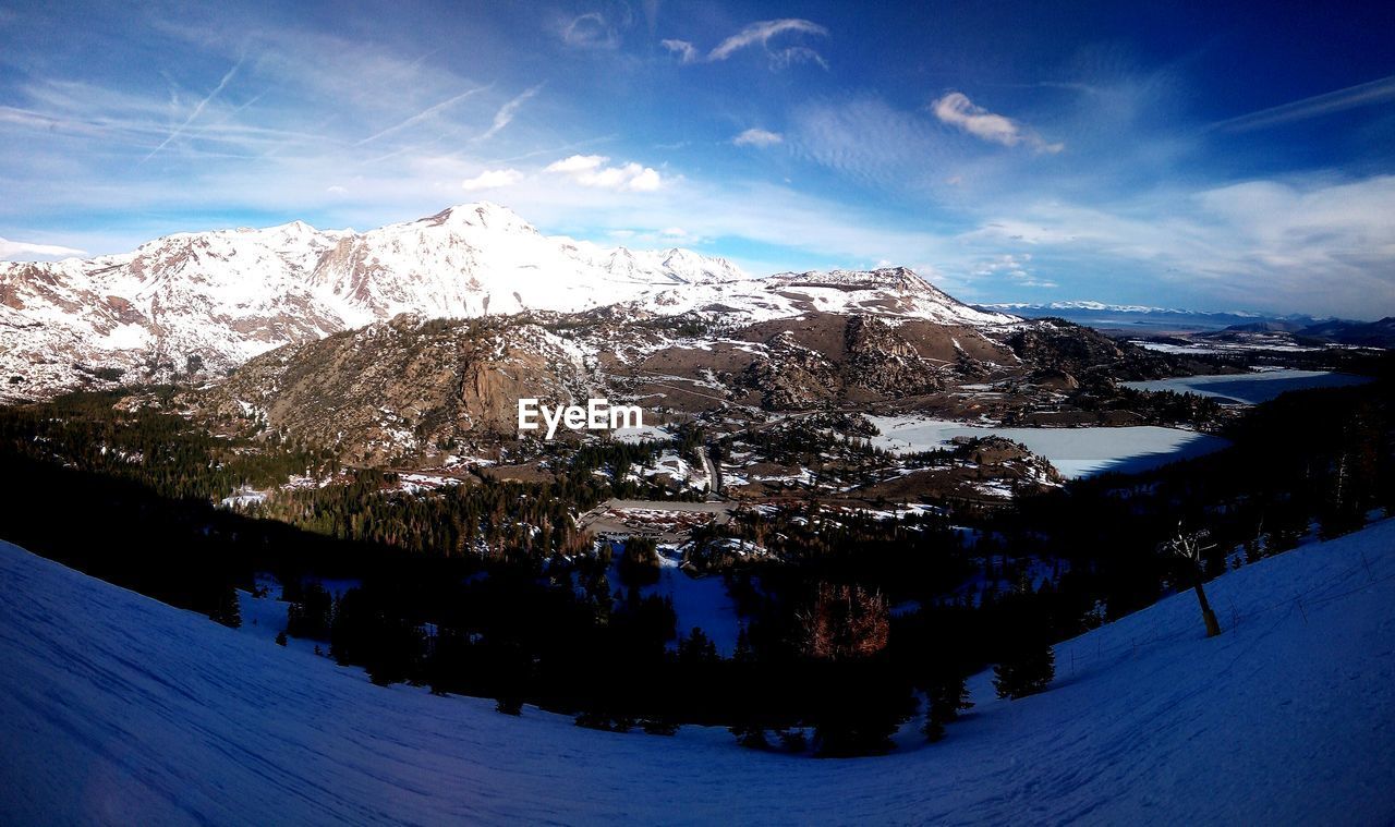 Scenic view of snowcapped mountains against blue sky