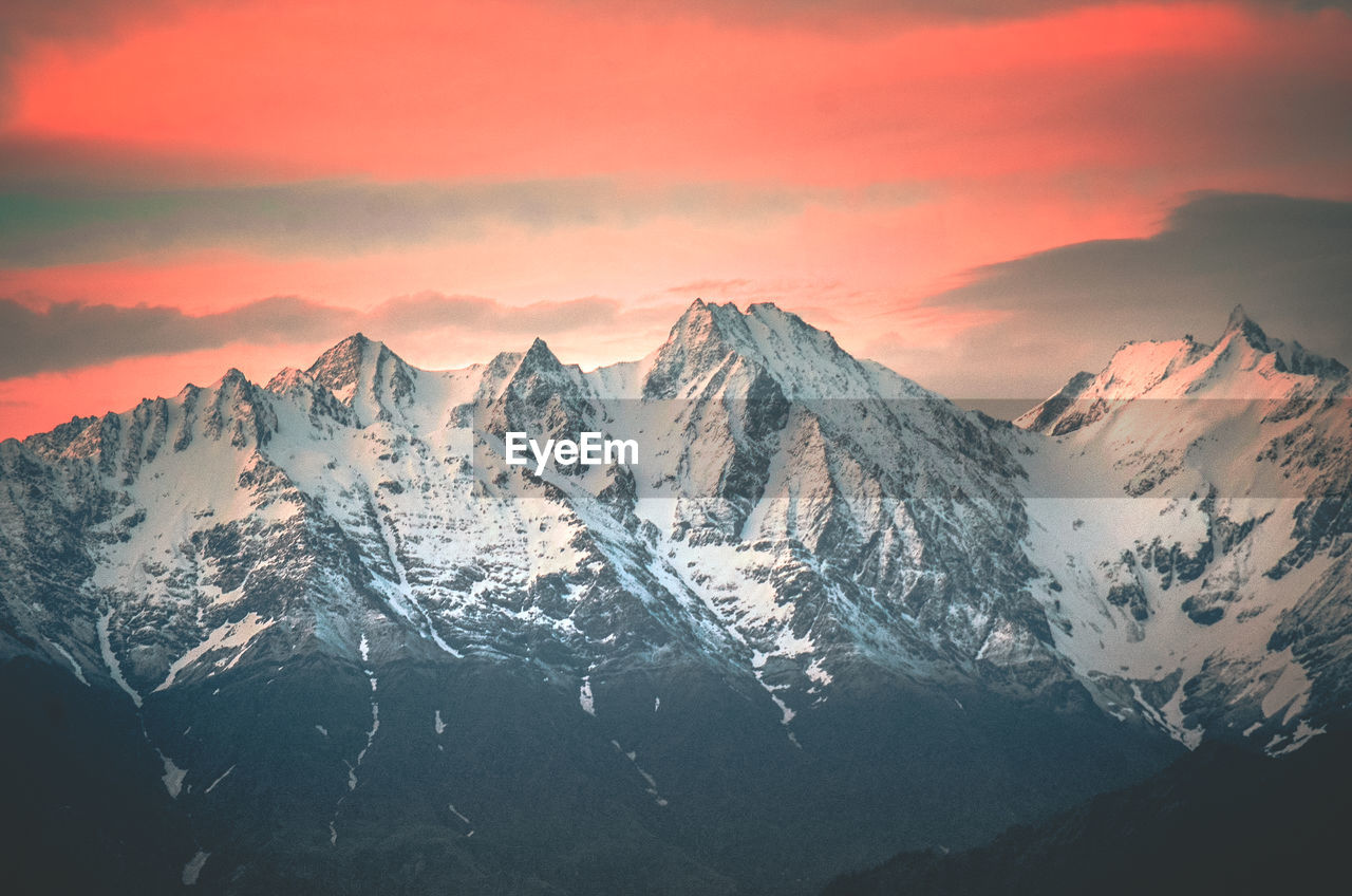 SCENIC VIEW OF SNOWCAPPED MOUNTAINS DURING SUNSET