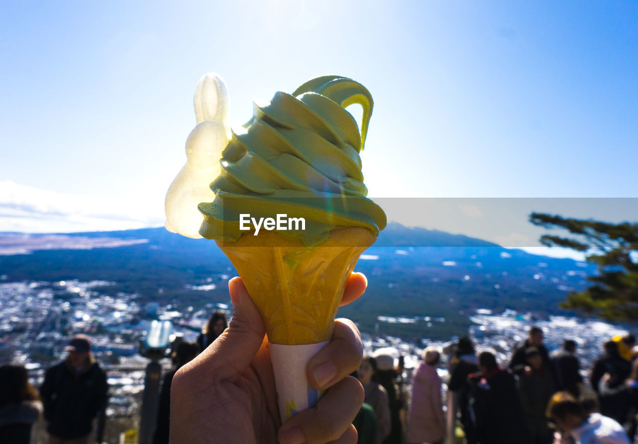 CLOSE-UP OF HAND HOLDING ICE CREAM CONE