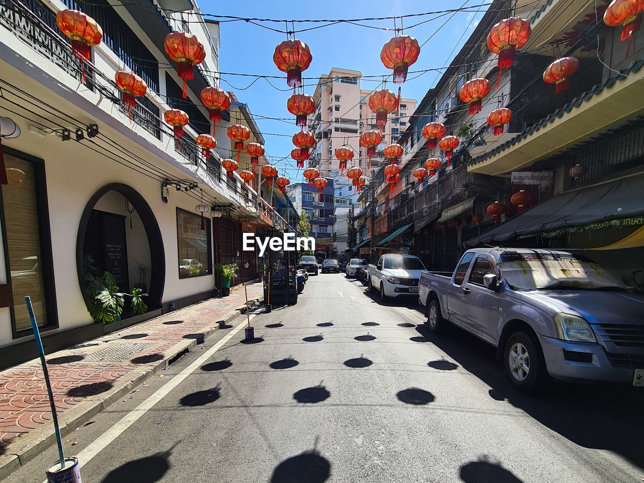 Lantern lined street amidst buildings in city