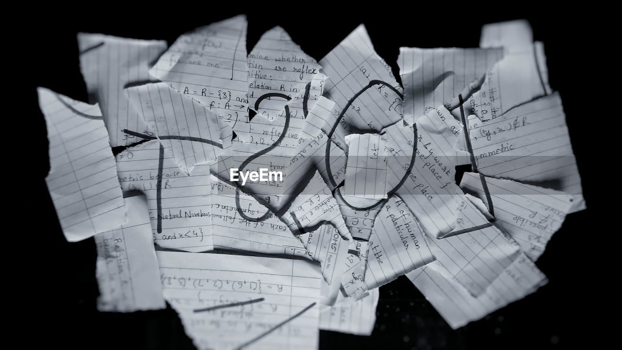 High angle view of torn papers on black background