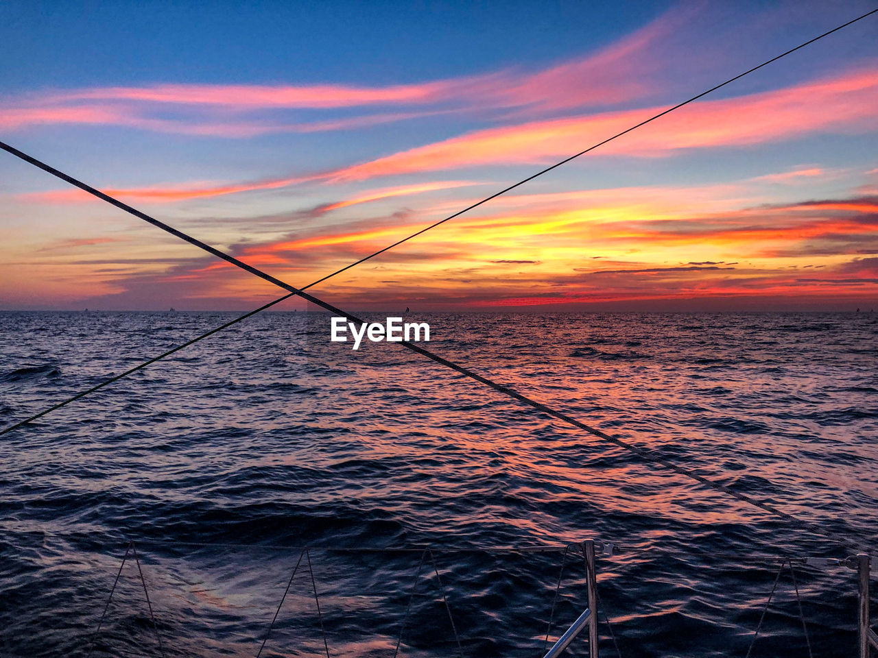 SCENIC VIEW OF SEA AGAINST ORANGE SKY DURING SUNSET