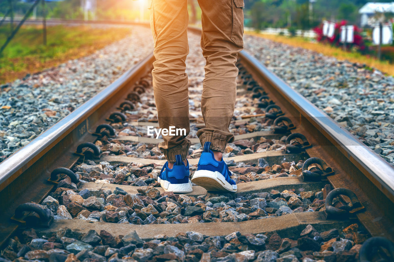 LOW SECTION OF MAN STANDING BY RAILROAD TRACK