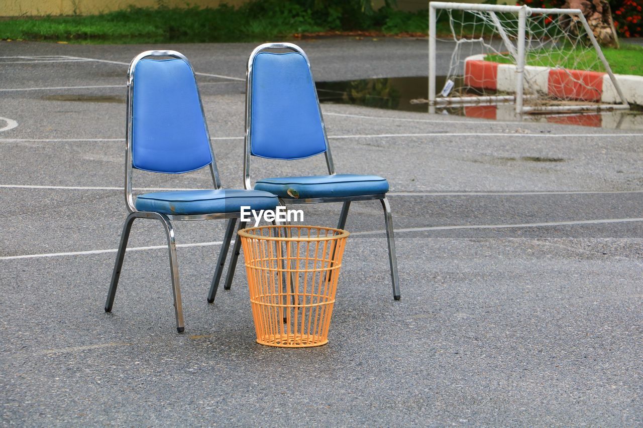 EMPTY CHAIRS ON STREET IN PARK