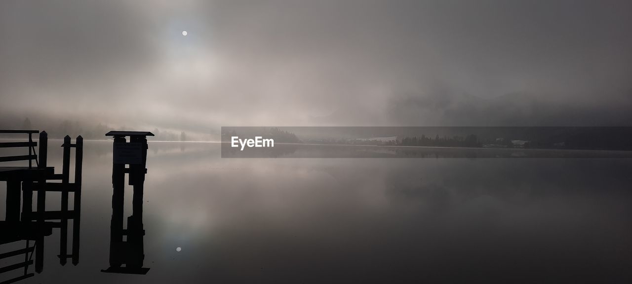 water, sky, cloud, fog, nature, tranquility, beauty in nature, lake, no people, morning, reflection, light, darkness, moon, scenics - nature, tranquil scene, mist, outdoors, night, pier, environment, architecture, dawn