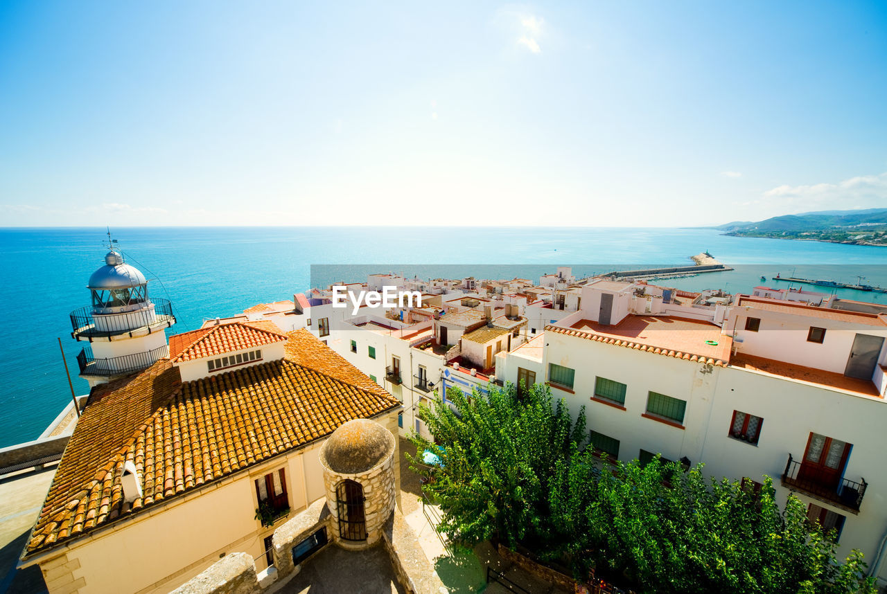 HIGH ANGLE VIEW OF SEA AND CITYSCAPE AGAINST SKY