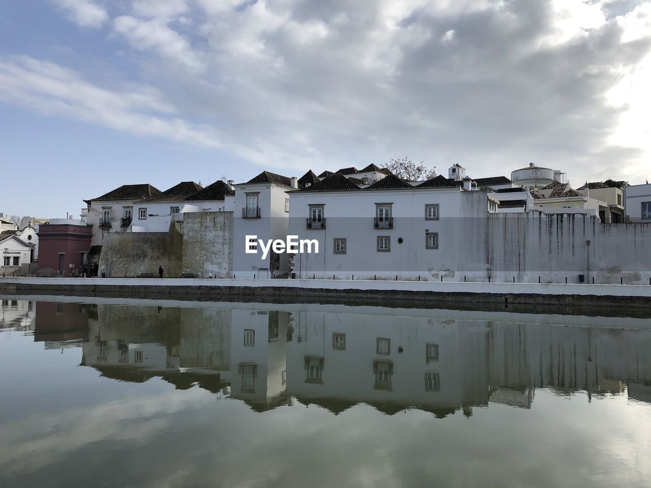 BUILDINGS BY LAKE AGAINST SKY