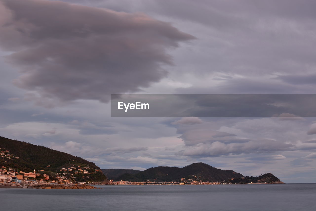 Scenic view of sea and mountains against sky